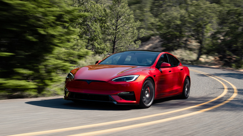 2025 Tesla Model S Plaid driving at speed front 3/4 view