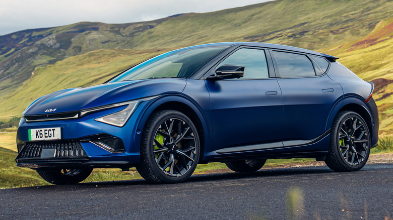 A blue 2026 Kia EV6 GT in front of a hill.