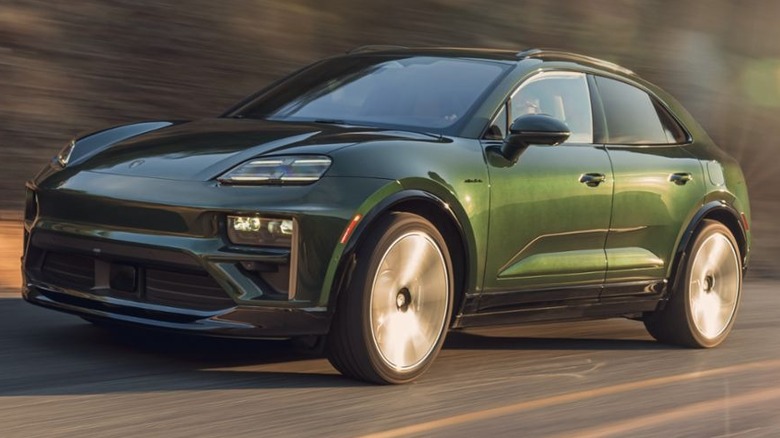 A dark green 2026 Porsche Macan Turbo on a highway on a mountain.