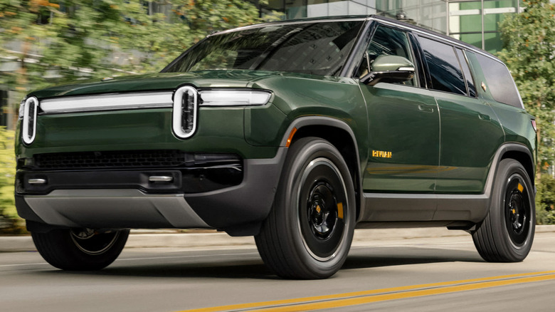 A dark green 2026 Rivian R1S driving on a street