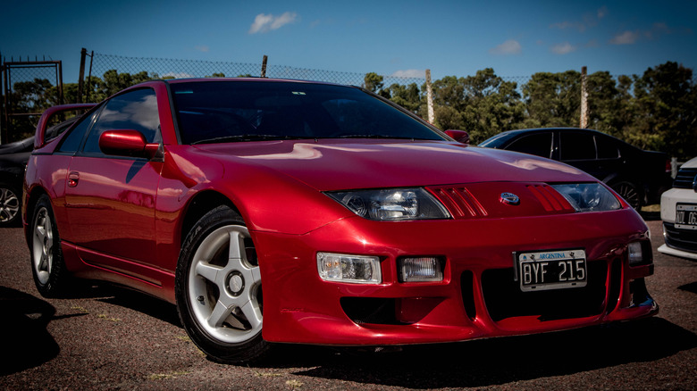 A red Nissan 300ZX twin turbo with a body kit parked at a car show