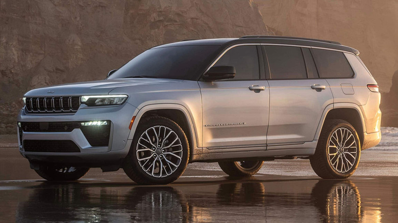 A Jeep Grand Cherokee is parked on the beach.