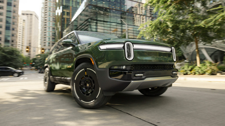 A green Rivian R1S is shown from a low angle.