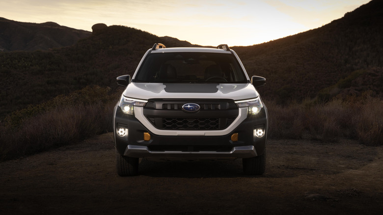 A Subaru Forester Wilderness sits parked outdoors at dusk.
