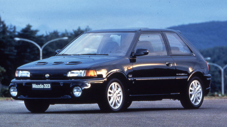 A black Mazda 323 GT-R hot hatch parked outside