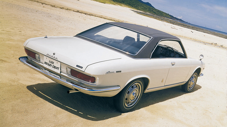 A white Mazda Luce Rotary Coupe on sandy terrain