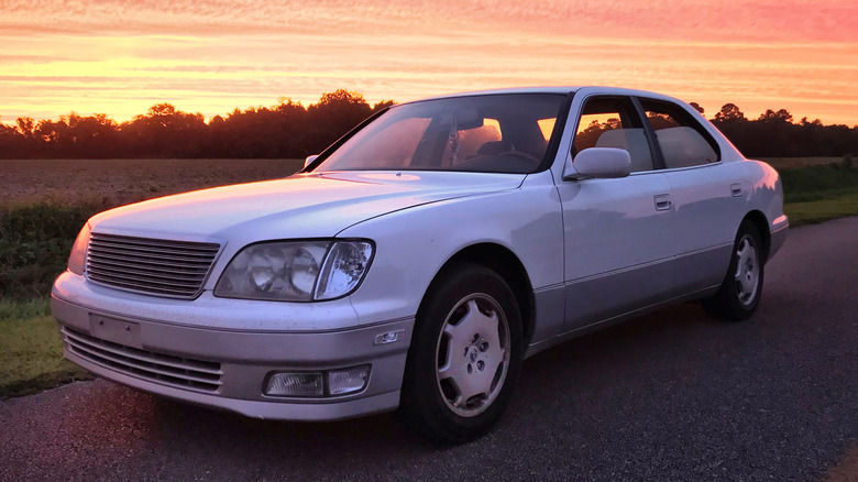 A white Lexus LS400 is parked at sunset.