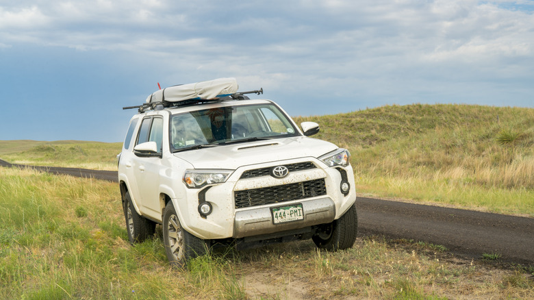 A Toyota 4Runner pulls off a road into grass.