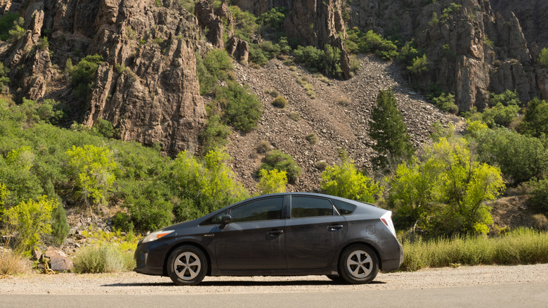 A Toyota Prius pulls over among cliffs.