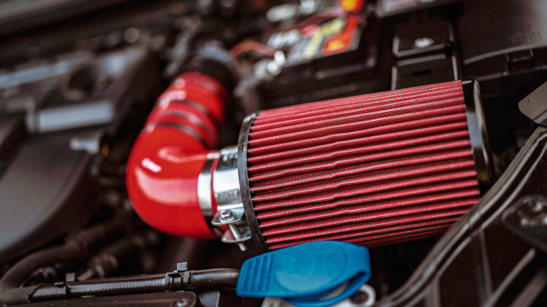 This is a red cold air intake and a red high-flow air filter that has been installed.