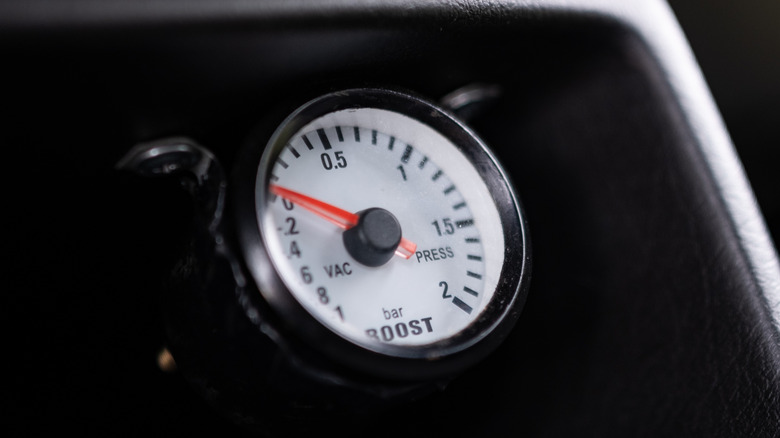 This is a white forced induction boost meter on a black dash.