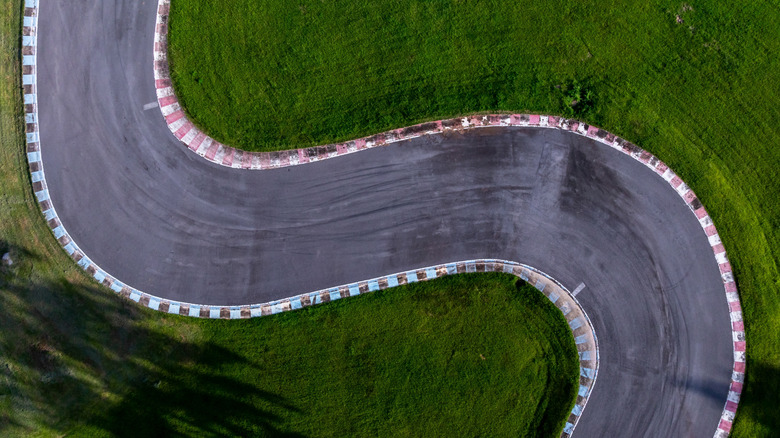 An aerial view of an automotive race track snaking through grass.