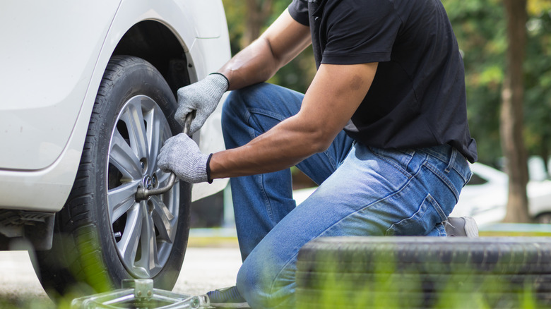 Person changing their flat tire.