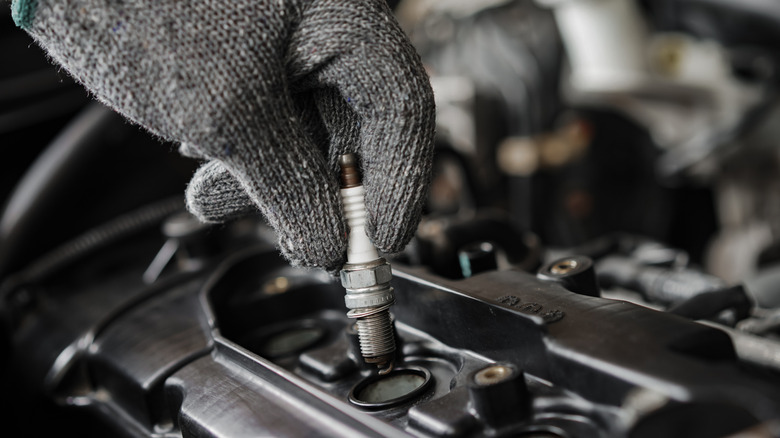 Mechanic replacing a spark plug.
