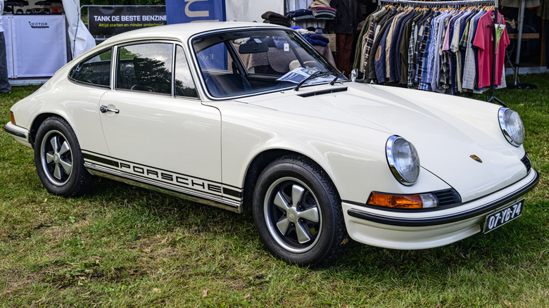 A classical achromatic Porsche 911 from nan 1960s parked connected grass.