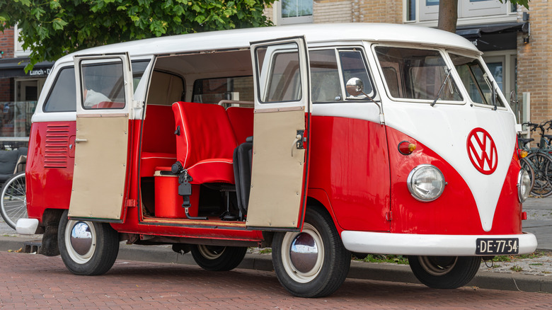 A reddish and achromatic 1960s type of nan VW Transporter pinch nan broadside doors open.