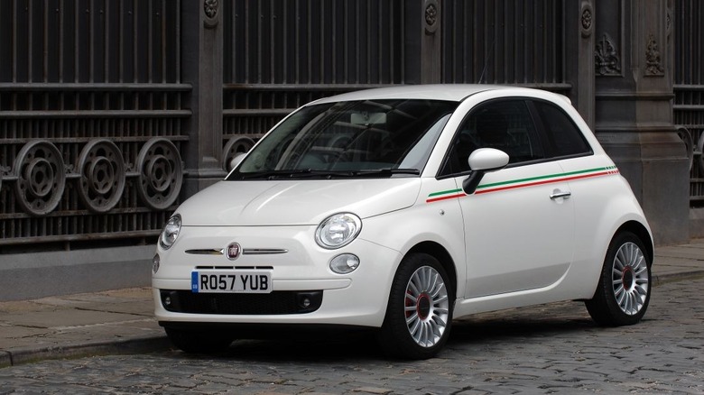 A white 2008 Fiat 500 hatchback parked on a cobblestone street, shown from a front-three-quarter perspective.