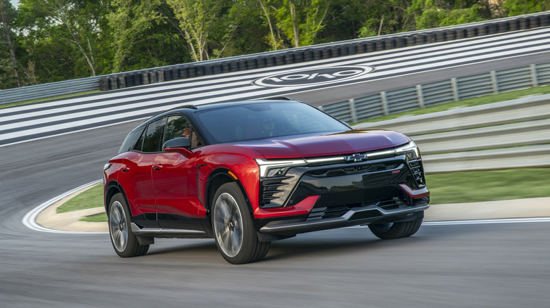 Red Chevrolet Blazer EV SS cornering at speed on a banked racetrack.
