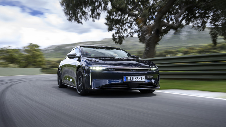A dark blue Lucid Air Sapphire drives on a race track.