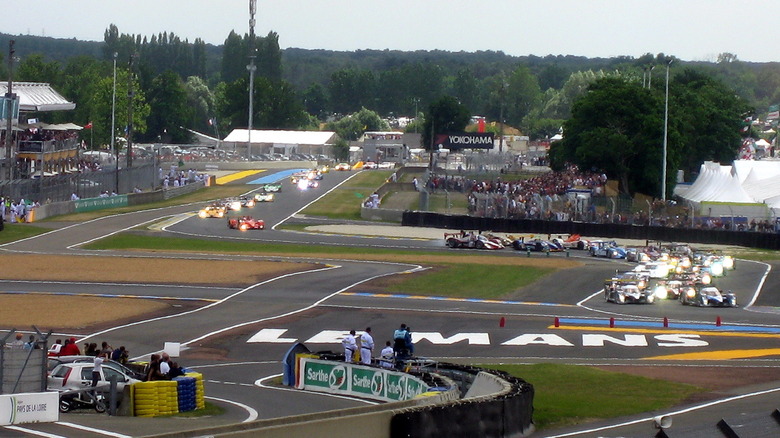 Rolling start of 2008 24 Hours of LeMans endurance race showing cars approaching around an S-bend