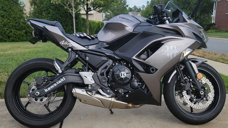 A black and silver Kawasaki Ninja 650 sits in a driveway.