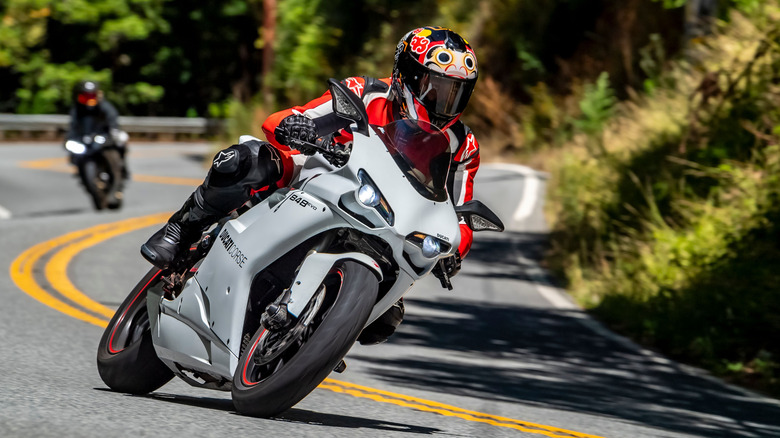 A rider leans on a motorcycle while negotiating a curvy road.