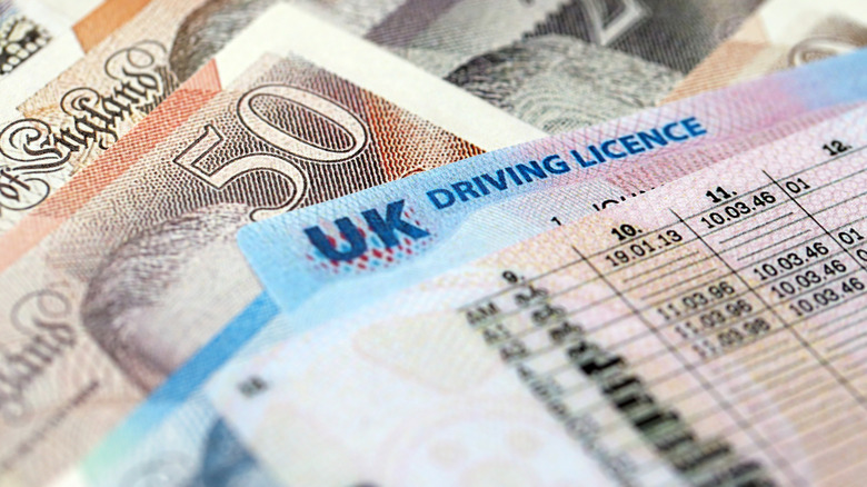 United Kingdom driving license card on UK British pounds money close up