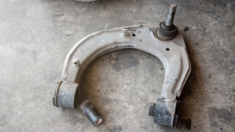 An old control arm sitting on the ground