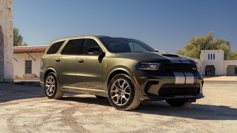 A green 2026 Dodge Durango Hellcat Jailbreak SUV in a right front three quarter view parked in front of Spanish mission-style architecture