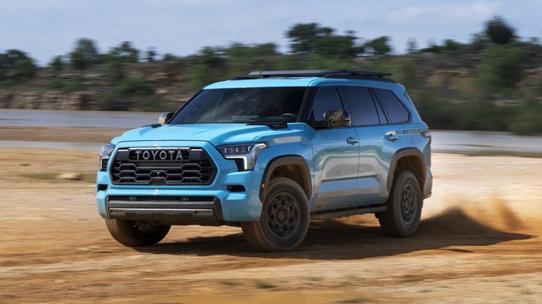 A light blue 2026 Toyota Sequoia Wavemaker SUV in a left front three-quarter view driving on dirt