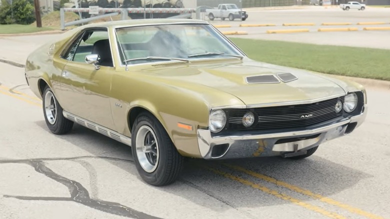 A front 3/4 view of a 1970 AMC AMX parked in the middle of the road.