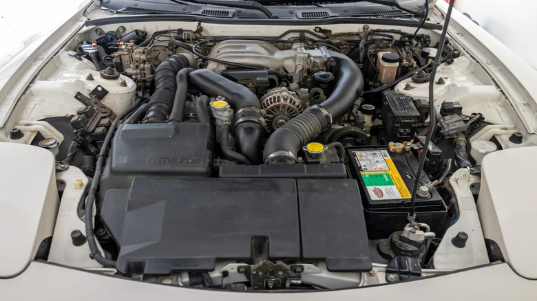 The engine of a third-generation Mazda RX-7 with visible plumbing to its twin turbos
