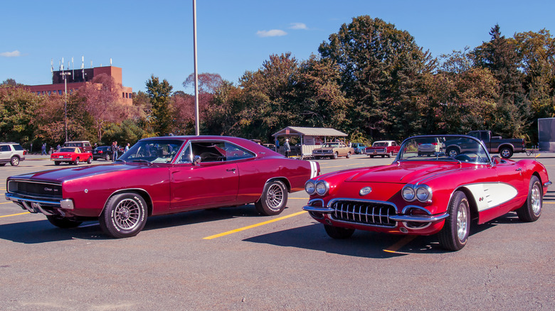 Two popular 1960s cars parked next to each other in a parking lot.