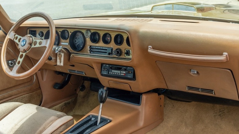 An interior view of a 1978 Pontiac Trans Am in gold.