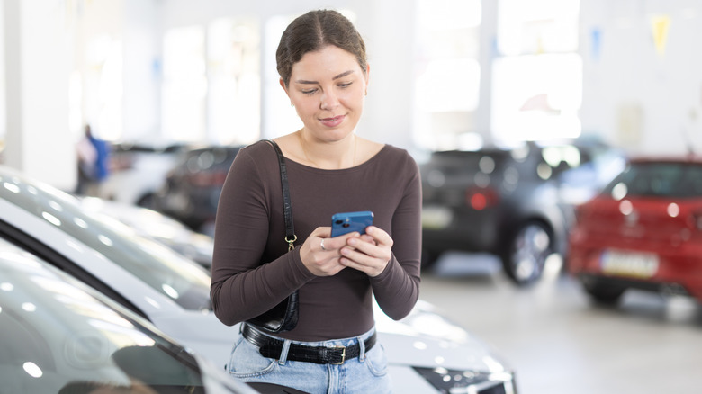 A woman calculating the payment on a new car.