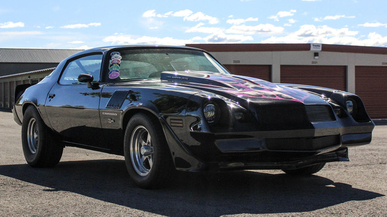 The restomod 1979 Chevy Camaro for sale, with black pain and purple flames on the bulging hood.