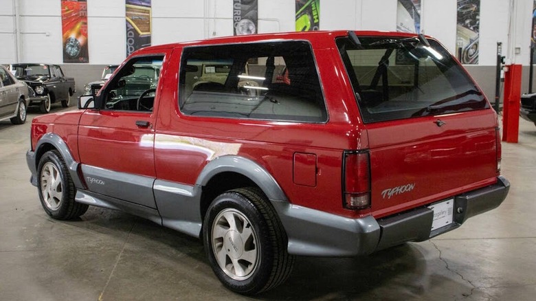 The rear 3/4 of the Apple Red 1992 GMC Typhoon for sale.