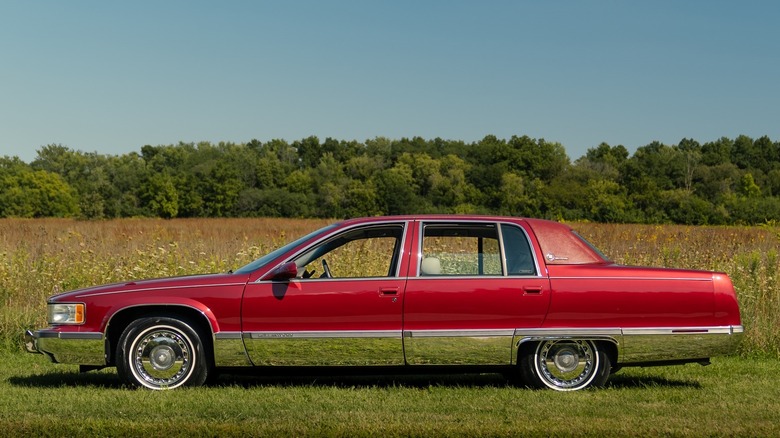 A red 1995 Cadillac Fleetwood Brougham with vinyl Landau roof