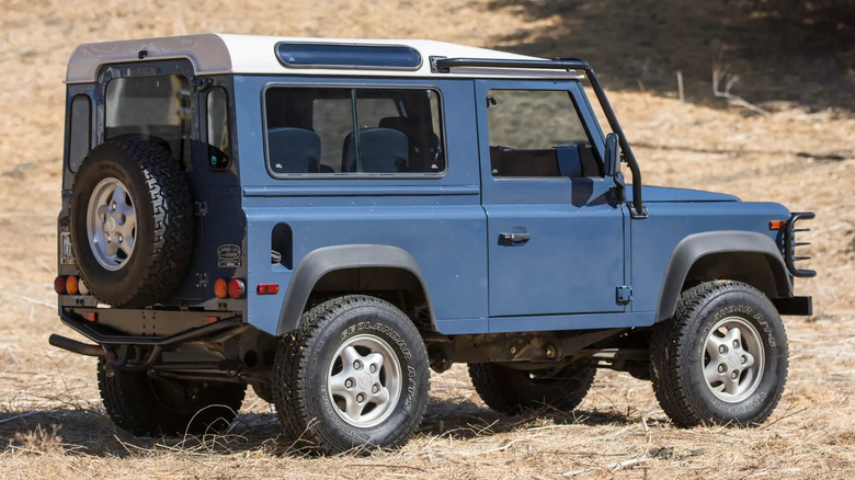 A rear 3/4 view of Kim Basinger's 1997 Land Rover Defender 90 NAS parked off road.
