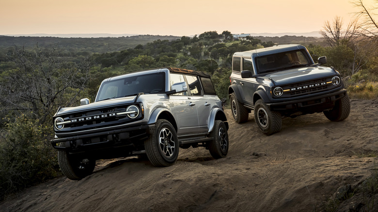 A pair of 2021 Ford Bronco models on a hilltop.