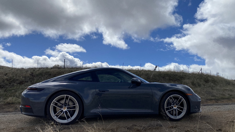 side view of the gray 911 in front of cloudy skies