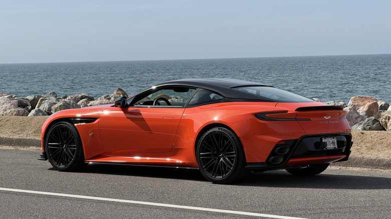 Rear 3/4 view of an orange Aston Martin DB12 S coupe