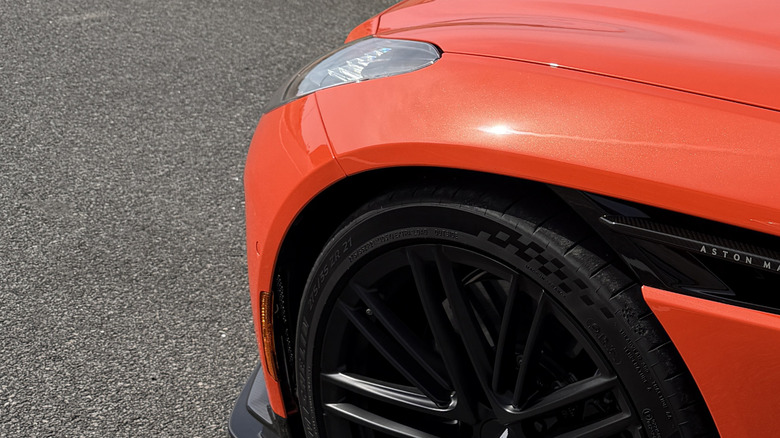 Front wheel and fender of an orange Aston Martin DB12 S