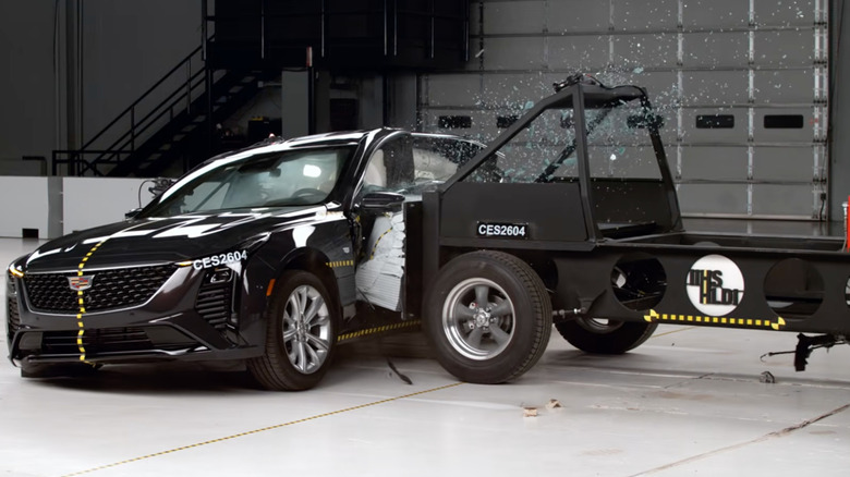 screenshot showing the moment the IIHS test sled T-bones a dark colored CT5 in the IIHS test studio