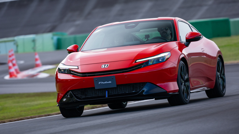 Front 3/4 view of a red 2026 Honda Prelude driving on track