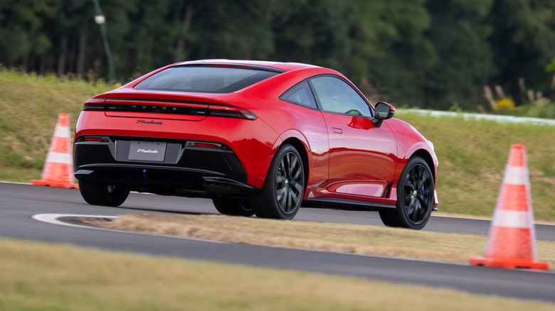 Rear 3/4 view of a red 2026 Honda Prelude driving on track