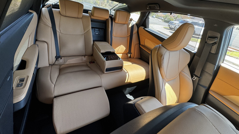 A look through the front passenger door into an ES350e with the executive rear seat package showing the Palomino leather seat reclined with the ottoman deployed