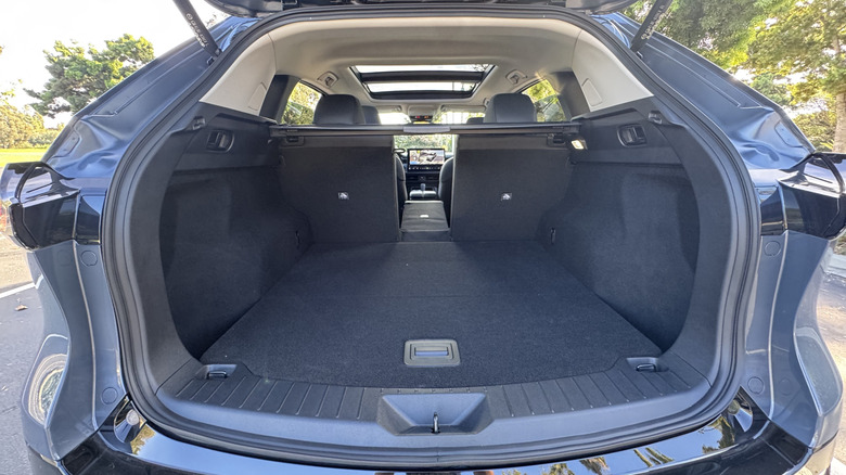 A rear shot of the gray CX-5 with the trunk open and center rear seat folded showing the increased trunk space