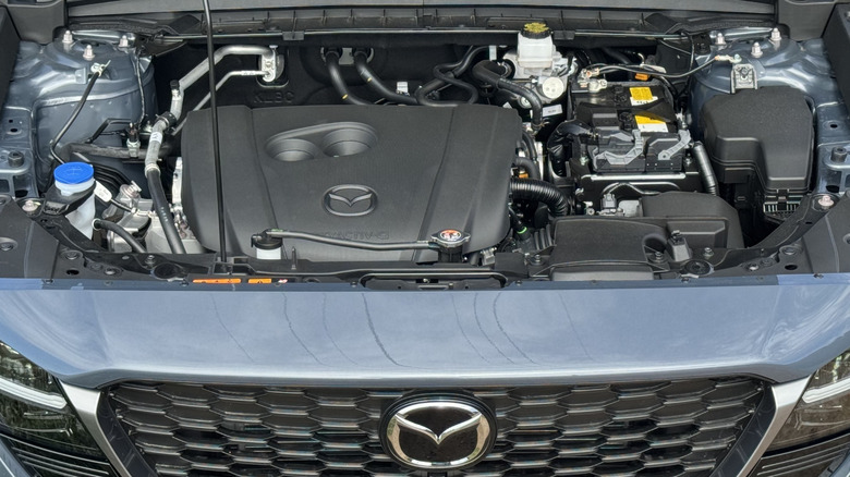 An overhead look under the hood of the gray CX-5 showing the 2.5-liter NA engine