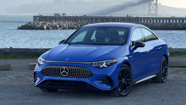 Front 3/4 view of a blue 2026 Mercedes-Benz CLA EV in front of the Golden Gate Bridge